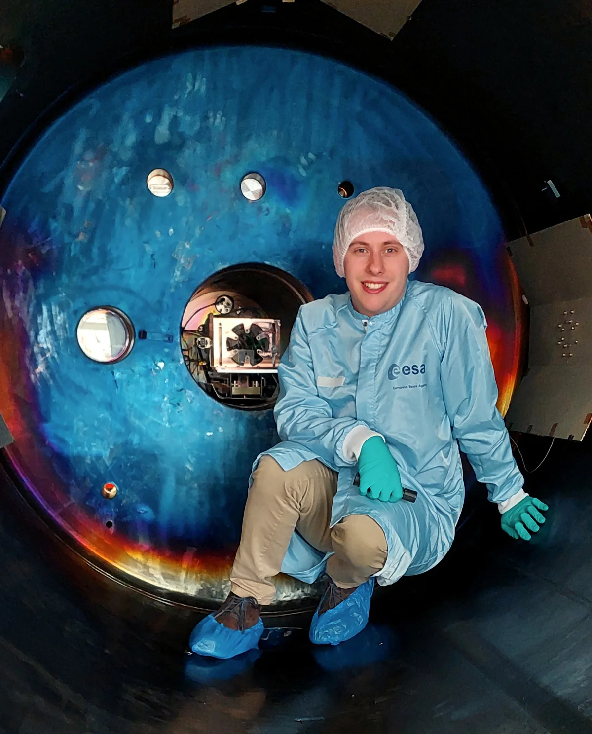 Alex Daykin-Iliopoulos wearing cleanroom clothing inside a vacuum test chamber at ESA ESTEC